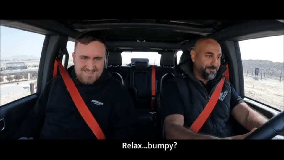 Two men in a car, wearing seatbelts, looking at the camera.  "Relax... bumpy?" is written below.