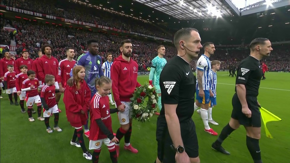 Soccer players and children carrying a wreath onto a field.