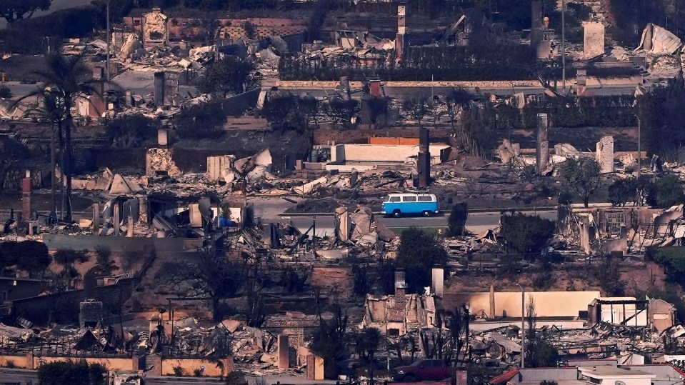 A blue van amidst fire-damaged homes.