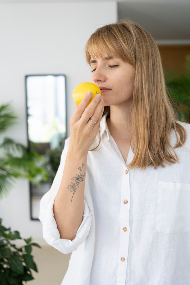 Woman smelling a lemon.