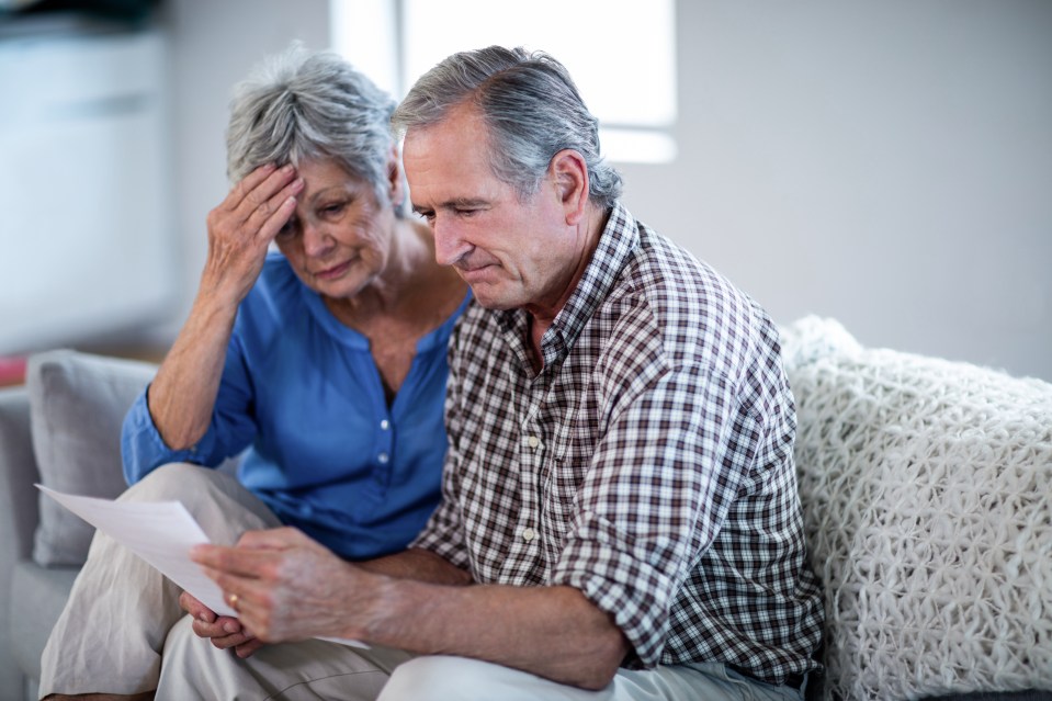 Worried senior couple checking the bills at home