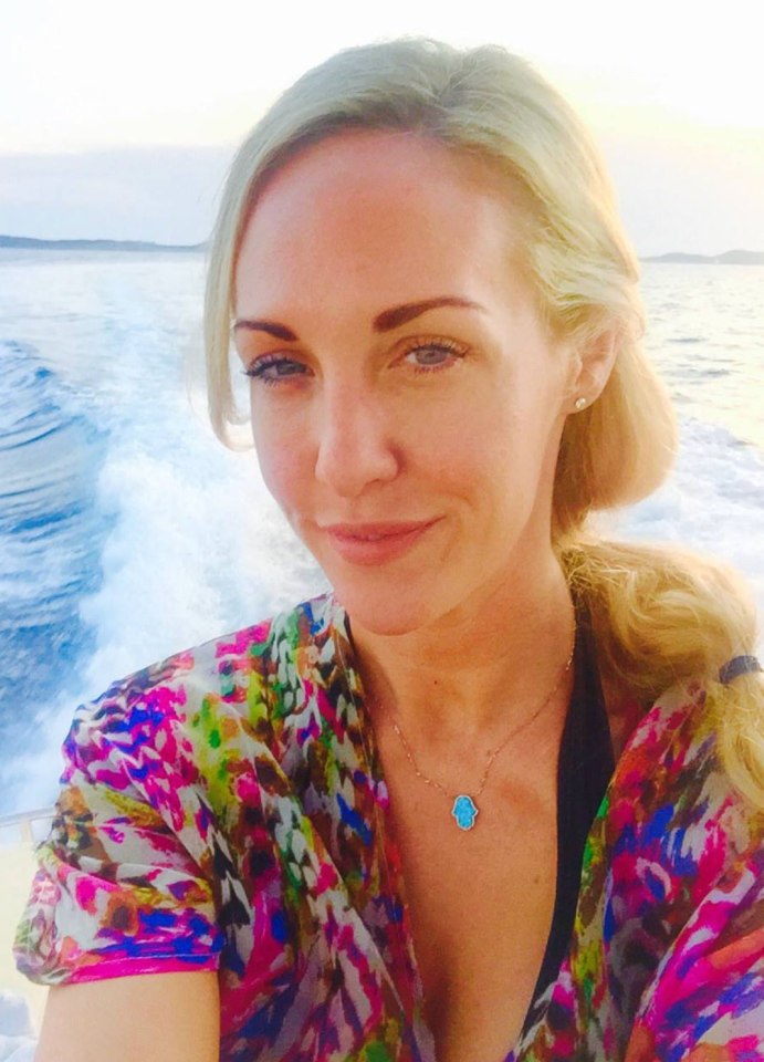 Woman on a boat wearing a colorful shirt and hamsa necklace.