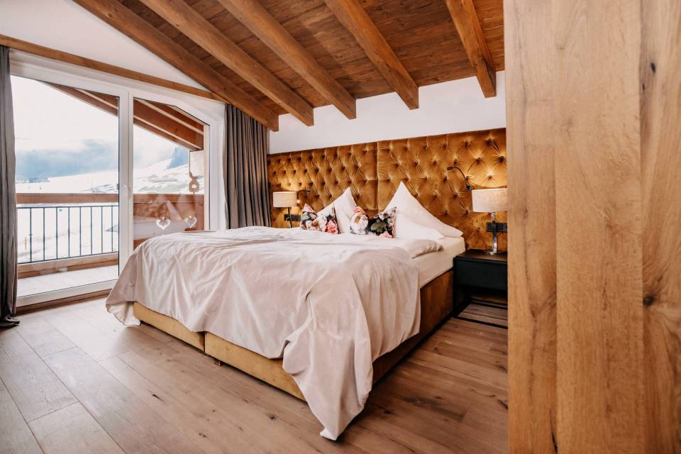 Hotel room with a large bed and mountain view.