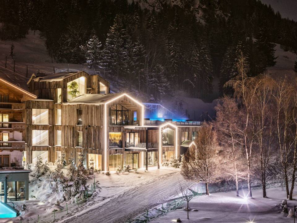 Night view of a snow-covered wooden hotel.