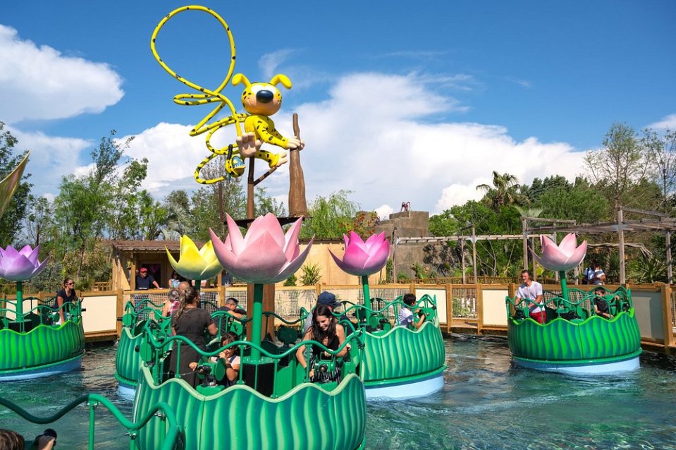 Parc Spirou Provence water ride with lilypad boats and a large Spirou statue.