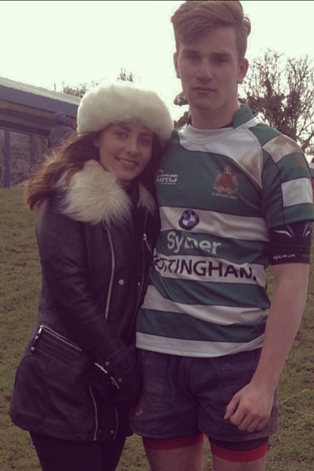 Photo of a young woman and man standing together outdoors.