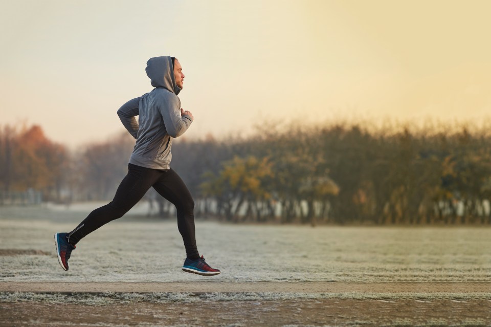 Man jogging in a park on a cold morning.